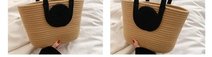 Detail of contrast cotton rope woven tote bag with sturdy black handles and khaki texture