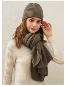 Detailstruktur des braunen Stricksets aus Mütze und Schal an einem Model