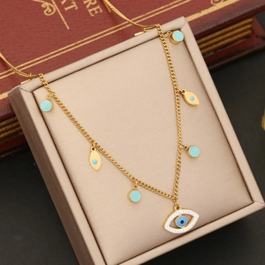 Gold evil eye necklace with blue accents and leaf charms on a premium jewelry box