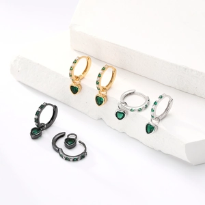 Detailed macro view of S925 silver heart earrings with green zircon and pavé crystals