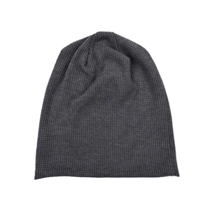 Macro detail of dark grey waffle knit beanie showing thick texture and soft warm fabric