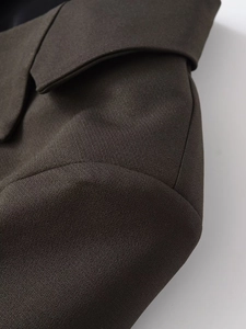 Macro detail of high-quality dark brown twill fabric on a tailored blazer shoulder