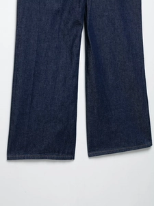 Primer plano de la textura denim azul oscuro y costuras en el bajo del pantalón