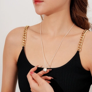 Détail du pendentif goutte brossé sur fine chaîne serpent portée par un mannequin