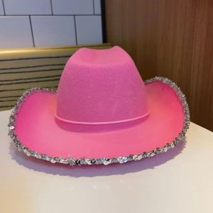 Close-up of pink western cowboy hat with sparkling silver sequins on the brim detail