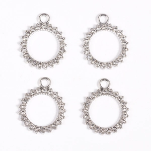 Close-up of four silver circular rhinestone pendants for DIY jewelry making and crafts