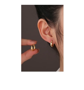 Close-up of minimalist double-layer 14K gold plated silver hoop earrings on female ear