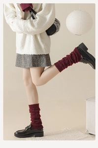 Détail de jambières en tricot bordeaux avec texture plissée et matière chaude