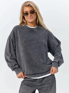 Detail of dark grey acid wash cotton sweatshirt with vintage texture and ribbed cuffs