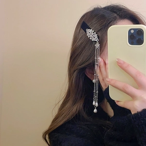 Detail of silver tassel hair clip featuring vintage flower motifs and pearl pendants
