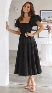 Close-up of black puff sleeve dress with layered ruffle skirt and smocked bodice details