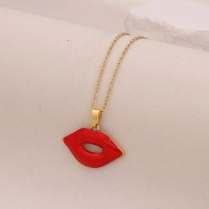 Golden stainless steel necklace with red enamel lip pendant on a white textured background