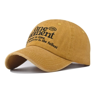 Detail of One Moment embroidery and vintage washed texture on ginger baseball cap