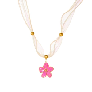 Detailed close-up of pink flower pendant with gold trim on a soft fabric ribbon necklace
