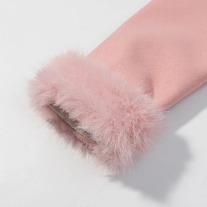 Dettaglio della manica di un cappotto di lana rosa con polsino in pelliccia e trama
