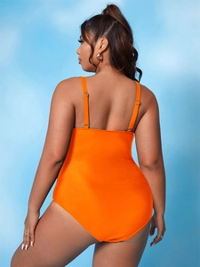 Detail of plus size orange one-piece swimsuit with open back and adjustable straps