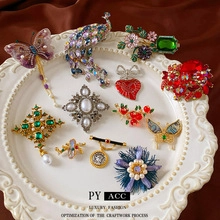 Detail of vintage style brooches with colorful crystals and pearls on red silk background
