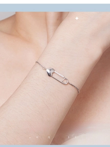 Macro view of S925 sterling silver safety pin bracelet with zircon heart on wrist