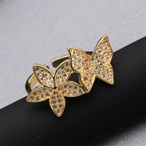 Adjustable gold butterfly ring with micro-paved white zircons on a matte stand