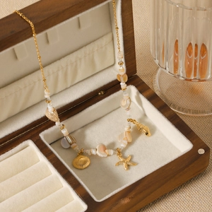 Gold stainless steel ocean necklace with shell beads and starfish charms in a jewelry box