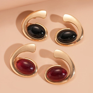 Detail of vintage gold-tone spiral earrings with oval black and deep red resin stones