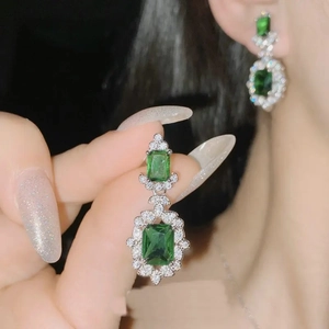 Luxurious silver stud earrings featuring rectangular green zircon and surrounded by small diamonds