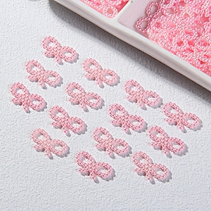 Close-up of pink beaded bow accessories for DIY phone cases and craft projects