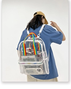 Clear PVC backpack detail featuring rainbow top handle and white straps on a model