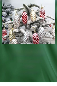 Close-up of snow-dusted Christmas pine cone ornaments in red, gold and silver