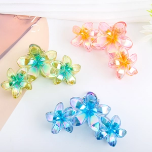 Three jelly-colored frangipani hair claws with iridescent pearl finish and flower design