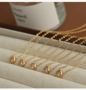Close-up of golden geometric hexagonal pendant necklaces with round zirconia inlay details