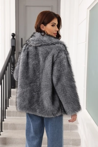 Detail view of the gray faux fur coat texture and long hair plush back design on model