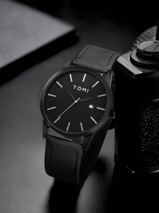 Macro detail of minimalist black watch dial with date window and leather strap texture