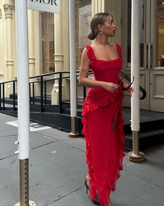 Detailed view of red dress with ruffle trim and high slit on city street
