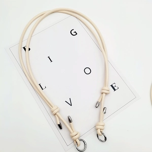 Detail of off-white leather strap with decorative knot and silver star clasp