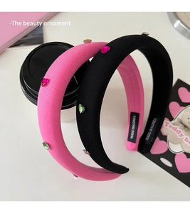 Close-up of pink sponge headband with colorful heart rhinestones and Made in Korea tag