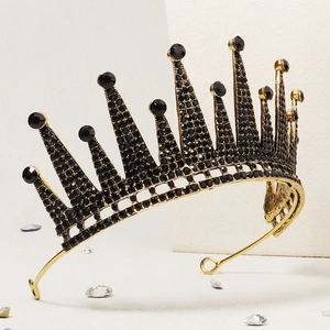 Close-up of golden crown featuring black rhinestones and intricate pointed spire design