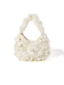 Macro shot of 3D satin rose flowers on a white crescent evening bag for weddings