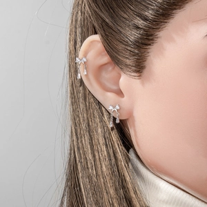 Silver bow tassel earring and ear cuff set with sparkling zircon on model ear