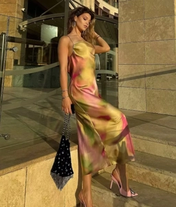 Detail of artistic tie-dye satin dress with cross back straps and draped neckline