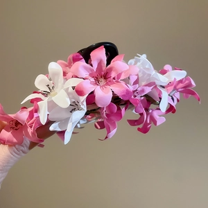 Détail d'une pince à cheveux avec fleurs en tissu rose et base noire élégante