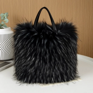 Elegante borsa a mano in finta pelliccia nera con manici in pelle in un set da studio