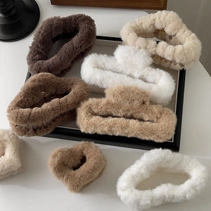 Close-up of plush rectangular claw clips and heart fuzzy hair accessories in earthy tones