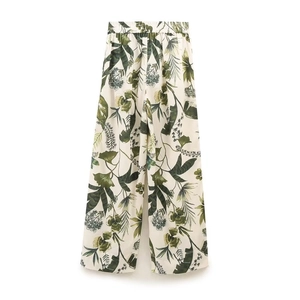 Detail of floral wide-leg trousers with tropical leaf print and elastic waistband