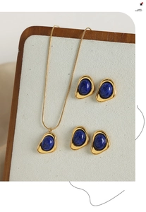 Detailed shot of gold-plated titanium jewelry set with inlaid blue lapis lazuli stones