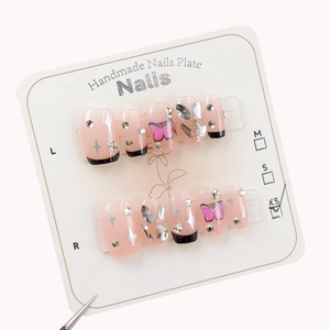 Faux ongles faits main avec pointes françaises noires, papillons roses et strass brillants