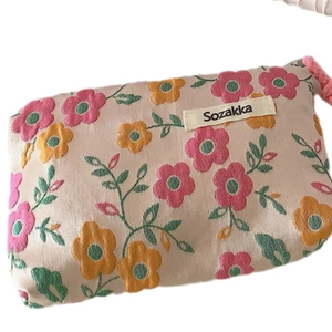 Floral canvas drawstring makeup bag with pink and yellow flowers on cream fabric