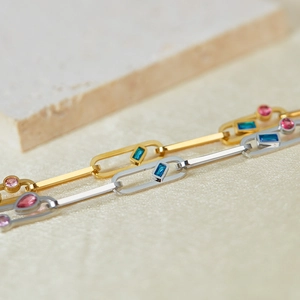 Gros plan de bracelets en or et argent avec pierres bleues et gemmes roses