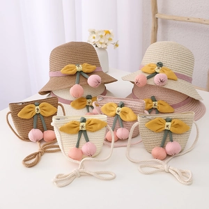 Detail of straw hat and matching bag set featuring cute cherry and floral accents