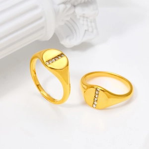 Close-up of elegant gold rings with a vertical row of clear zircon on a white background